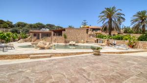 a backyard with a swimming pool and a house at Residence Il Corallo - Guitgia in Lampedusa +66 photos