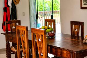 ein Holztisch mit Stühlen und einer Obstschale in der Unterkunft Looking Samaipata in Samaipata