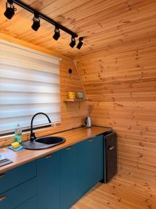 a kitchen with a sink and a wooden wall at Mountain Stories Kazbegi-Stepantsminda in Kazbegi +10 photos