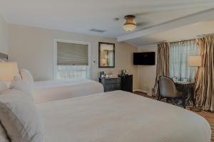 a hotel room with two beds and a desk at Coast Village Inn in Santa Barbara +22 photos