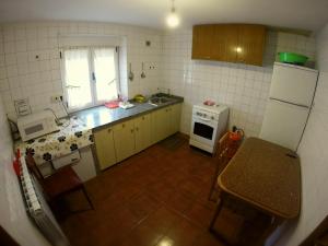 a small kitchen with a white refrigerator and a table at Alojamientos turísticos VUT-LE-043 in Villablino