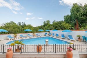 a swimming pool with chairs and umbrellas at Palmer Residence Krk in Dobrinj +41 photos