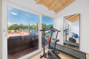 a gym with a large window and a exercise bike at Palmer Residence Krk in Dobrinj