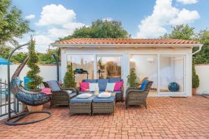 a patio with wicker chairs and a blue couch at Palmer Residence Krk in Dobrinj