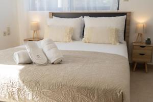 a bedroom with a large bed with white pillows at Fos Opus - Seaside Residence Rhodes in Ixia