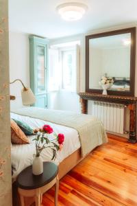a bedroom with a bed with a table and a mirror at Villa Luxa in Sintra