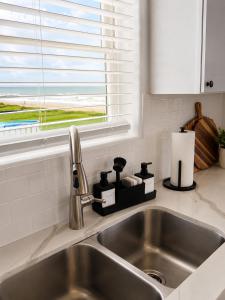 a stainless steel sink in a kitchen with a window at Beachfront Luxe, Ocean Views, Hot tub, Firepit, Sleeps 14 in Bolivar Peninsula +70 photos