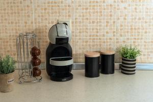 a coffee maker sitting on a counter with three cups at Fos Opus - Seaside Residence Rhodes in Ixia