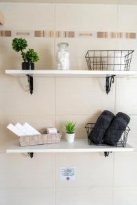 a room with white shelves with pillows and plants at Fos Opus - Seaside Residence Rhodes in Ixia +11 photos