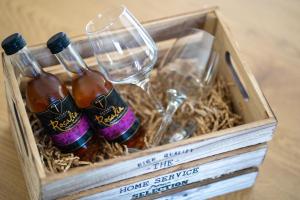 a wooden box with three bottles and a wine glass at Fos Opus - Seaside Residence Rhodes in Ixia