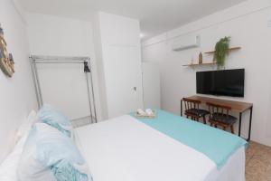 a bedroom with a bed and a desk and a television at Pousada Casa da Adriana in Fortaleza