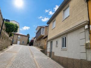 an empty street next to a brick building at O recuncho - Alojamiento tranquilo cerca de Ribeira Sacra y Ourense in Maceda +10 photos
