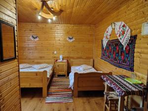 a room with two beds in a log cabin at Cabana Ghetari in Gheţari