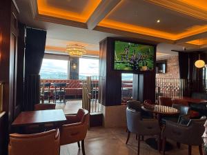 a restaurant with tables and chairs and a television on the wall at Bayview Lodge in Downings