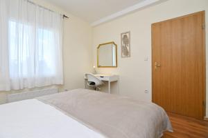 a bedroom with a bed and a desk and a mirror at Brko's Place Sinj in Sinj