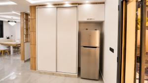 a stainless steel refrigerator in a room with a table at Les 3 perles in Ras El Ma