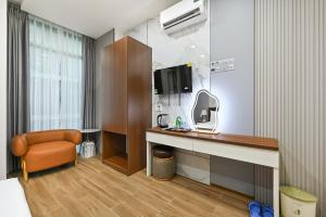 a room with a desk with a tv and a chair at The Crown Airport Hotel in Ho Chi Minh City