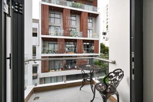 a balcony with a table and chairs and a building at The Crown Airport Hotel in Ho Chi Minh City