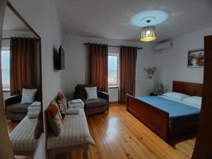a living room with a bed and a couch at EniGuesthouse in Gjirokastër