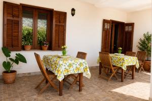 eine Terrasse mit zwei Tischen und Stühlen und Fenstern in der Unterkunft Grimaldi B&B in San Vito lo Capo + 22 Fotos
