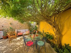 a patio with a table and chairs under a tree at A Casa das Nenas in Villanueva de Arosa