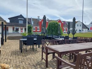 a group of tables and chairs with umbrellas at Tversted Strandkro in Bindslev