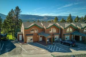 a large house with a car parked in a parking lot at Marble Canyon in Fairmont Hot Springs