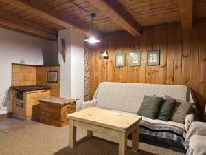 a living room with a couch and a table at Chalupa Jaseň in Ždiar