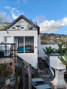 a white house with a view of the ocean at Isabela House in Ponta do Sol
