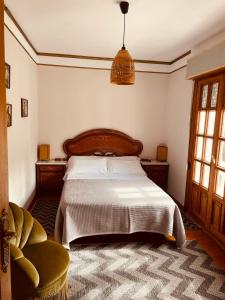a bedroom with a bed and a chair at Villa Horta in Horta +14 photos