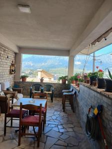 a patio with tables and chairs and a view of mountains at EniGuesthouse in Gjirokastër