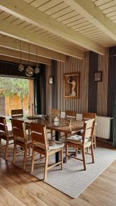 a dining room with a wooden table and chairs at Belis Chalet in Bălceşti