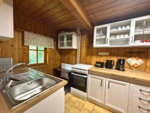 a kitchen with white cabinets and a sink at Chalupa Jaseň in Ždiar +16 photos