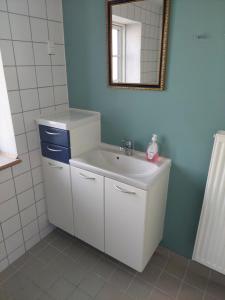 a bathroom with a white sink and a mirror at Tversted Strandkro in Bindslev +19 photos
