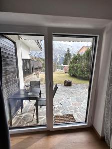 a sliding glass door leading to a patio with a table at Grimming Lodge Tauplitz II in Tauplitz