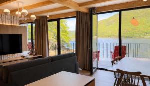 a living room with a couch and a large window at Cormorant Rock Chalets in Ingonish Beach