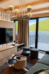 a living room with a tv and a large window at Cormorant Rock Chalets in Ingonish Beach