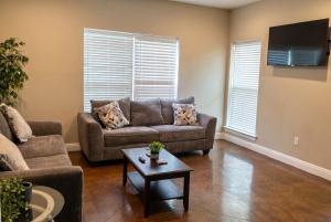 a living room with a couch and a table at Ground Floor, 3BR Sleeps 8, Near Ingalls and Chevron -F- in Moss Point