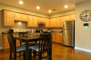 a kitchen with a table and a refrigerator at Ground Floor, 3BR Sleeps 8, Near Ingalls and Chevron -F- in Moss Point
