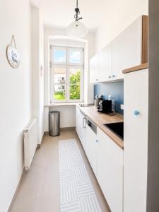 a white kitchen with white cabinets and a window at Casa Roberto, Apartment 2 in Mariazell
