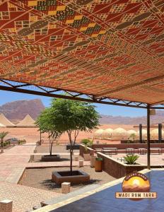 a view of a desert with a tent and a tree at WADI RUM TARA lUXURY CAMP in Wadi Rum