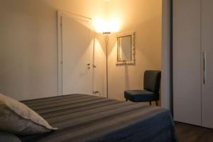 オルヴィエートにあるAppartamento la Piazzettaのベッドルーム1室(ベッド1台、椅子、ランプ付)