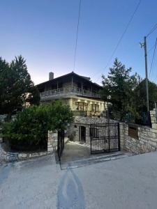 a stone house with a gate in front of it at Stone House Berat in Dushnik