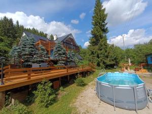 a hot tub on a deck next to a house at Dom Prowansalski in Jaworzynka