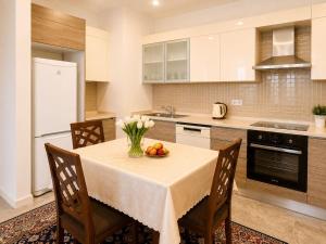 a kitchen with a table with a vase of fruit on it at Bishkek Park Apartments in Bishkek