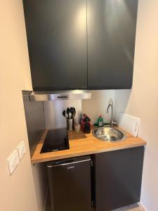 a small kitchen with a sink and a counter at Le Col Getaway Virage 5 in Le Bourg-dʼOisans +3 photos