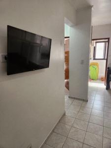 a living room with a flat screen tv on a wall at Apto Sol Nascente in Mongaguá