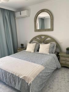 a bedroom with a large bed and a mirror at Cura Marina in Playa del Cura +5 photos