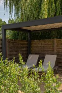 two lounge chairs under a pergola in a garden at Vakantiewoning Conterdijk 13 in Koksijde