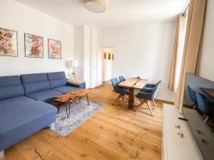 a living room with a blue couch and a table at Casa Roberto, Apartment 2 in Mariazell